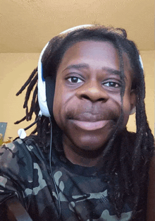 a man with dreadlocks wears headphones and a nike shirt