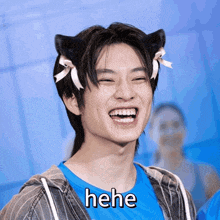a young man wearing cat ears and a shirt that says " hehe " on it
