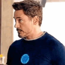 robert downey jr. is wearing a blue t-shirt with a blue heart on the chest .