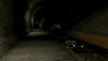 a woman in a red and black costume is walking down a dark tunnel .