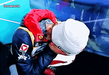 a man wearing a white hat and a red jacket with the word biemme on it