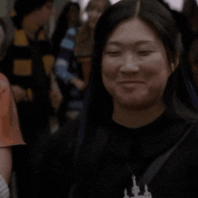 a woman wearing a black shirt and a necklace with a castle on it