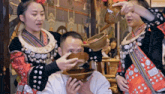 a man is being poured a drink from a bowl by a woman