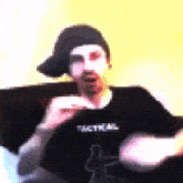 a pixelated image of a man wearing a black shirt that says tactical on it
