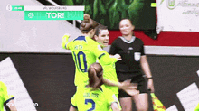 a group of female soccer players are hugging each other on a field .