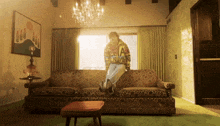 a person sitting on a couch with the letter a on their shirt