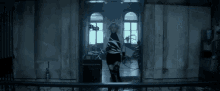 a woman is jumping in the air in front of a window