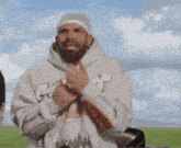 a man with a beard wearing a hoodie with the letter r on the front