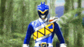 a blue and yellow power ranger is standing in the jungle