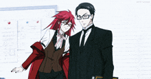 a man in a suit and tie stands next to a woman with red hair and glasses