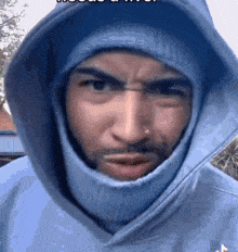 a man wearing a blue hoodie and a balaclava