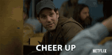 a man wearing a baseball cap says cheer up in a netflix ad