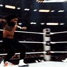 a shirtless wrestler in a boxing ring with a star on the corner