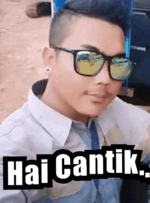 a man wearing sunglasses says hai cantik on the bottom of the image