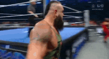 a man with a beard is standing in a boxing ring .