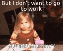a little girl is sitting at a table with a cup of coffee and a spoon in her hand .