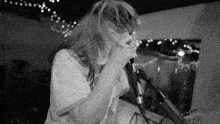 a woman singing into a microphone with her hair blowing in the wind ..