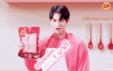 a man in a pink shirt is holding a bag of cp