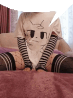 a person wearing a t-shirt with a cat on it is sitting on a bed