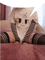 a person wearing a t-shirt with a cat on it is sitting on a bed