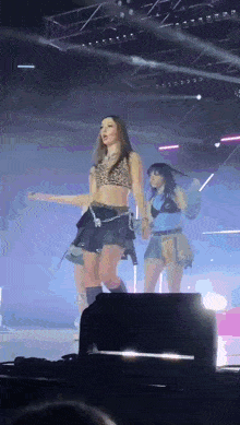a girl in a leopard print top is dancing on stage