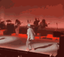 a group of people are standing on a stage in front of a red background .
