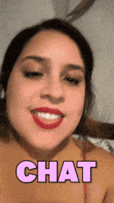 a woman with red lipstick is smiling and the word chat is above her