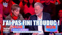a man and a woman sitting in front of a sign that says j ' ai pas fini trouduc