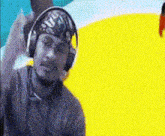 a man wearing headphones and a bandana on his head looks at the camera