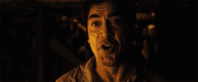 a close up of a man with his mouth open in a dark room