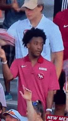 a man wearing a pink shirt that says alabama