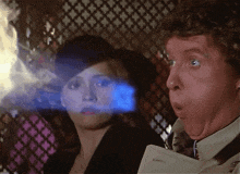 a man and a woman are looking at something with a surprised look on their face