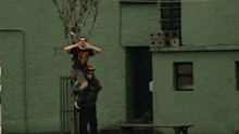 a man carrying another man on his shoulders has a t-shirt that says guns n roses on it