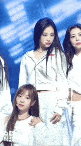 a group of girls are standing on a stage and one of them has a microphone in her hand
