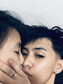 a man kissing a woman on the cheek with a diamond ring on his finger