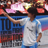 a person giving a peace sign in front of a sign that says to we expend fight effort tog with ether