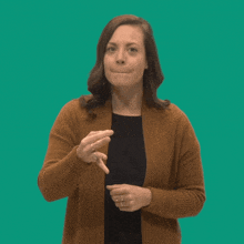 a woman wearing a brown cardigan and a black shirt is making a face