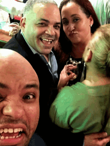 a group of people are posing for a photo and one of them is making a funny face