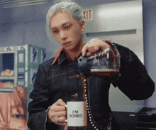 a man pouring coffee into a cup that says i 'm bored
