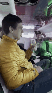 a man in a yellow jacket is holding a glass