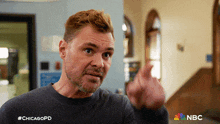 a man in a gray sweater is pointing at the camera with the hashtag #chicagopd on the bottom