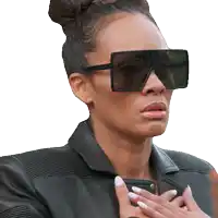 a woman wearing sunglasses and a leather jacket has her hand on her chest