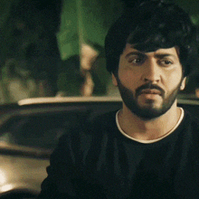 a man with a beard is looking at the camera