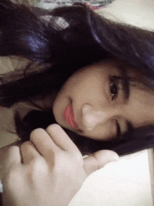 a close up of a woman 's face with a hand on her face