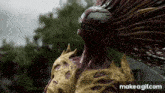 a statue of a monster with long hair is standing in the rain in front of a house .