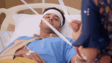 a man is laying in a hospital bed with a bandage on his head