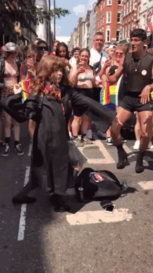 a woman in a harry potter costume is dancing in front of a crowd of people