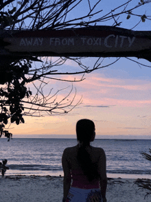 a woman stands in front of a wooden sign that says away from toxic city