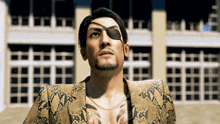 a man with a tattoo on his chest is wearing an eye patch and a snakeskin jacket