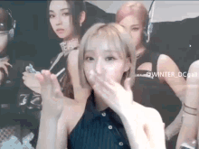 a woman is blowing a kiss in front of a group of girls .